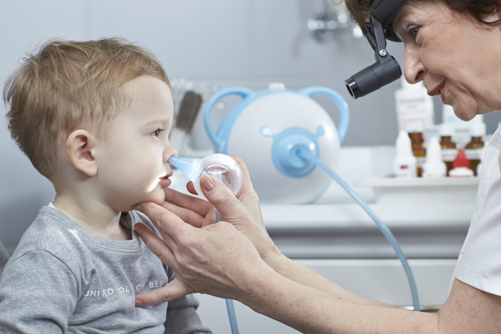 An ENT doctor clearing a boy's nose with the help of a safe baby nasal aspirator Nosiboo Pro