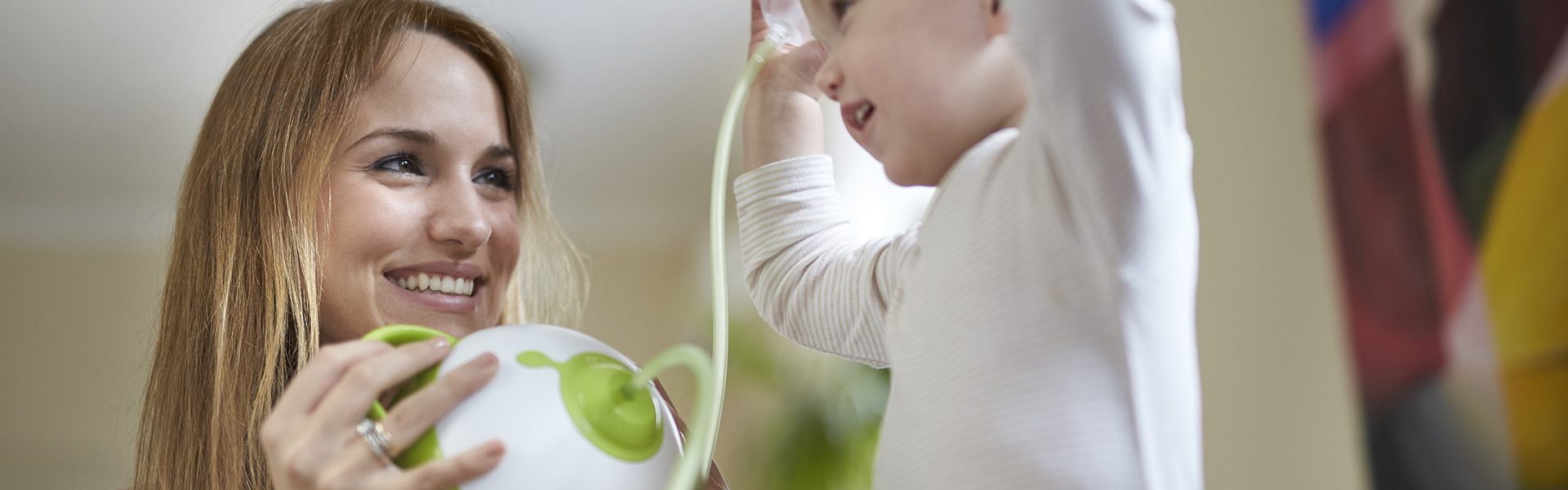 A woman clearing her son's nose with the help of the Nosiboo Pro Electric Nasal Aspirator