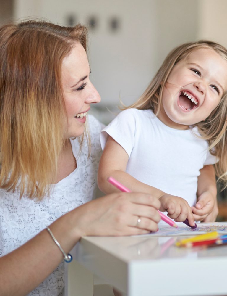 A mom and her little daughter drawing together