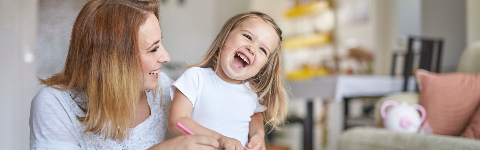 A mom and her little daughter drawing together